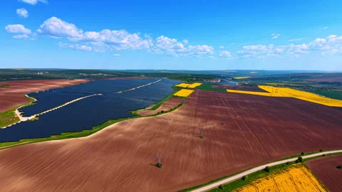Solar farm amid agricultural patchwork landscape. Panel arrays beside plowed Video stock 336899281