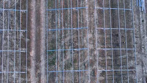 Solar farm construction site featuring metal frames and ground wiring, crea.. Stock Photos
