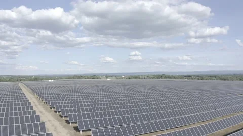 Solar farm: low over rows solar panels dramatic tilt down (ungraded, log gamma) Stock Footage 153929335