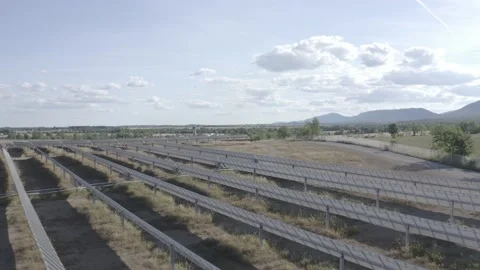Solar farm: Low overflight rows of solar panels sunny day (ungraded, log gamma) Stock Footage 153929288