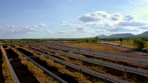 Solar farm: Low overflight rows of solar panels sunny day (color graded) Stock Footage 153942441