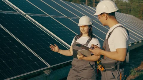 Solar farm with two engineers walk to check the operation of the system Stock Footage 257133677