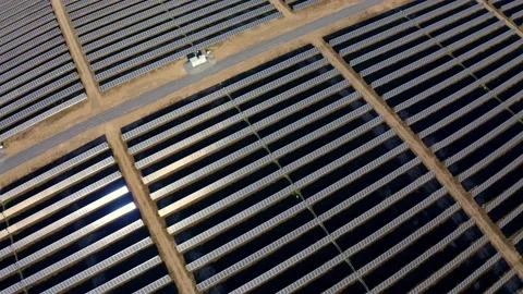 Solar farm: wide pullback over solar panels tilt up to sky (color graded) Stock Footage 153942502
