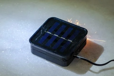 Solar light device on surface sparking as concept of electrical short circuit Stock Photos
