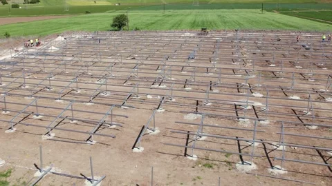 Solar mounting stands with workers and tractor orbit aerial Stock-Footage 332759407