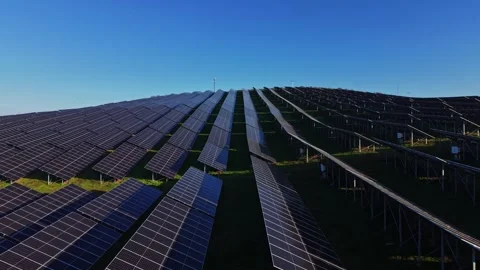 Solar panel array captures sunlight for energy generation in clear sky Stockbeeldmateriaal 329993721