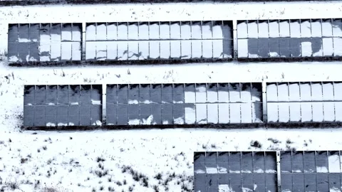 Solar panel array covered with snow on a field during winter, energy production Stock-Footage 334745607