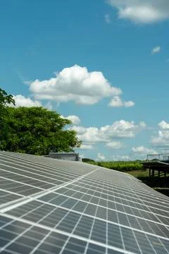 Solar panel arrays with clouds and blue skies in the background. Stock Photos