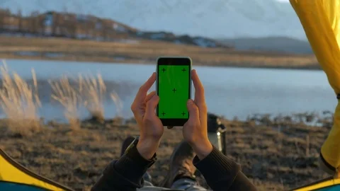 The solar panel attached to the tent. The man sitting next to mobile phone Stock Footage 75789450
