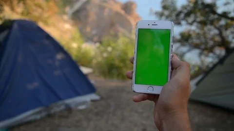 The solar panel attached to the tent. The man sitting next to mobile phone Stock Footage 79409244