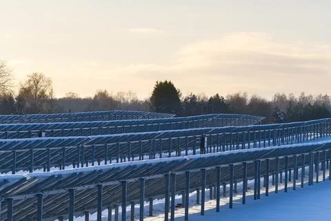 Solar panel back side field covered with snow. renewable energy in winter low Stock Photos