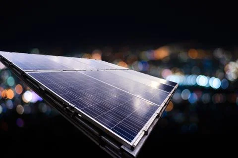 Solar panel with city night light bokeh. Stock Photos