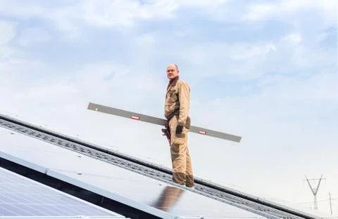 Solar panel energy. Electrical engineer man is working in solar station on roof Stock Photos