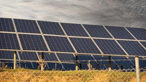 Solar Panel Farm Producing Renewable Energy Under Cloudy Sky Stockfoto's
