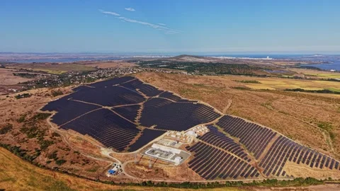 Solar panel farm in a rural area with clear skies and hills Stock Footage 344540631