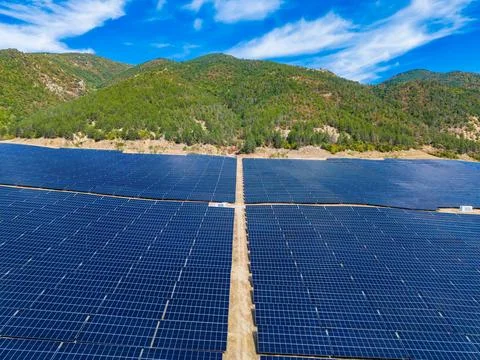 Solar panel field located in a mountainous area under blue sky with few cloud Fotos Stock