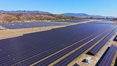 Solar panel field with rows of solar panels in a dry landscape under clear skies Stock Footage 347749409