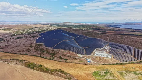 Solar panel field in a rural area during daytime with clouds and hills in the Stock Footage 346980140