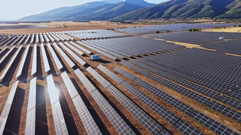 Solar panel field in a rural area with mountains in the background during Stock Footage 347761701