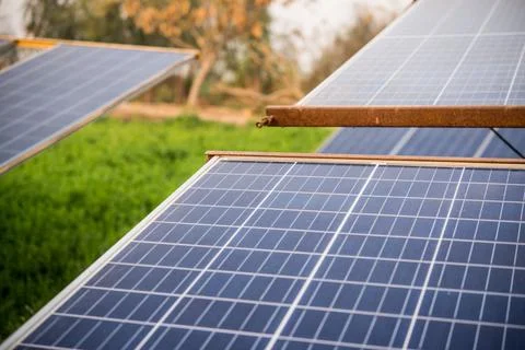 Solar panel with green fields in the background Stock Photos