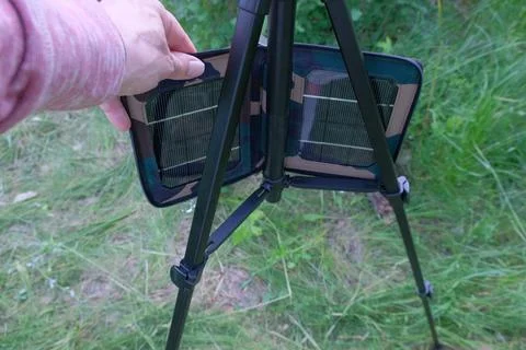 Solar panel in hand man on tripod you can see objects human hands forest grass Stock Photos