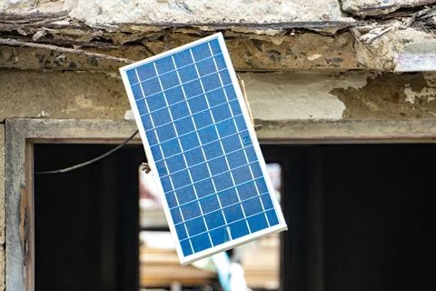 A solar panel hangs in the window of an old unmaintained building 스톡 사진