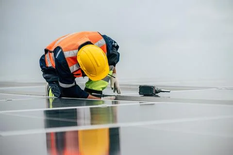 Solar panel installation activity by technician on a rooftop during dayligh.. Stock Photos