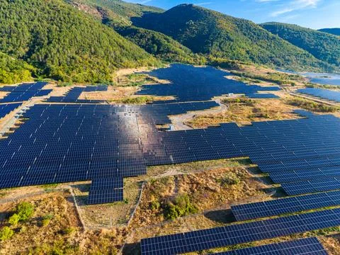 Solar panel installation on land among hills during daytime with clear sky Stock Photos