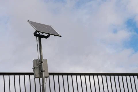 Solar panel installation on a metallic post under cloudy sky Stock Photos