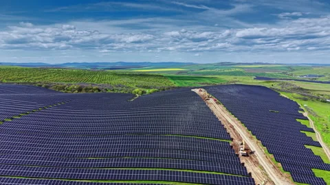 Solar panel installation process in a large field under blue sky with clouds Stock Footage 340148088