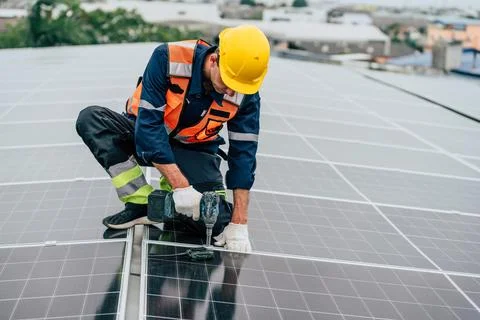 Solar panel installation on a rooftop by a skilled technician during daylight Stock Photos