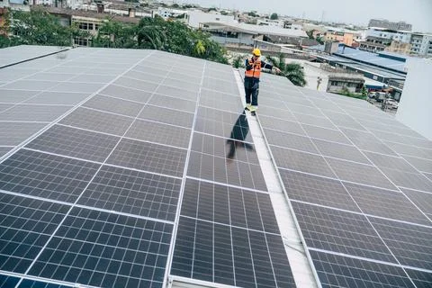 Solar panel installation on rooftop in an urban setting during daylight hours Foto stock