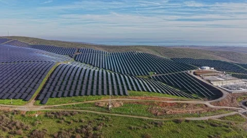 Solar panel installation spreads across rolling hills in clear weather Vidéo 330000795
