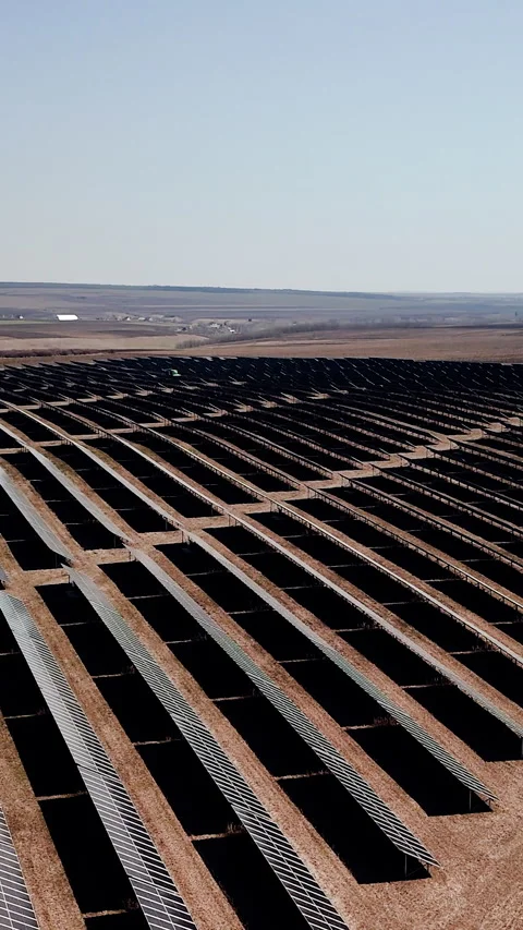 Solar panel installation in a vast desert landscape, showcasing rows of solar Stock Footage 337997695