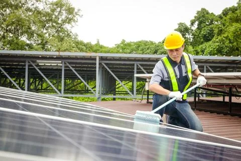 Solar panel installers use brushes to clean dust from solar panels Stock-Fotos