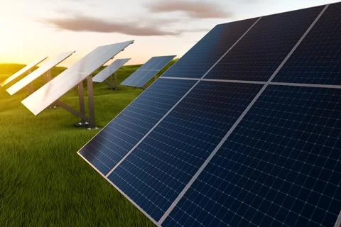 Solar panel modules at sunset in a field against a background of green grass. Stock Photos
