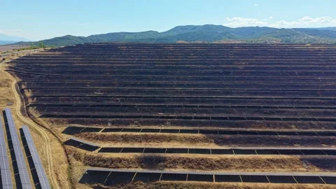 Solar panel rows cover broad dry slope in orderly renewable energy array Vídeo Stock 345972615