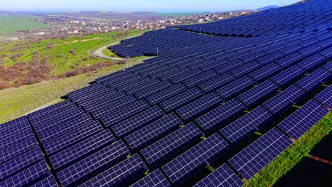 Solar panel rows curve across hillside near village, Bulgaria Stock Footage 340407418