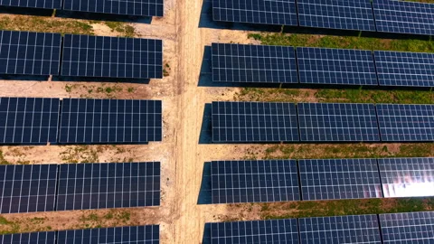 Solar panel rows divided by dirt path. Symmetrical dark modules arranged in grid Stock Footage 336899442