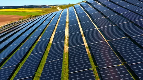 Solar panel rows on hillside. Converging lines of dark modules extend toward Stock Footage 336899762