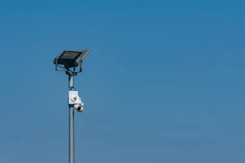 Solar panel with security camera stands under blue sky Stock Photos