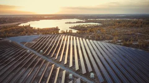 Solar panel station with reflection of sun and river on background. ECO system 库存照片