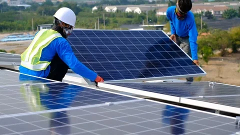 Solar panel technician installing solar panels on roof Stock Footage