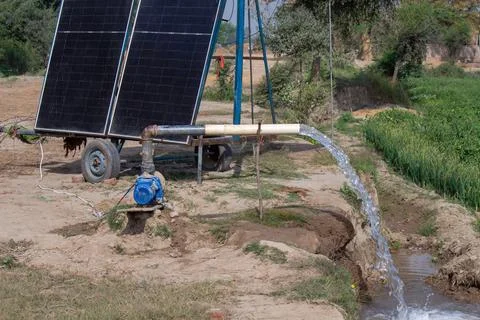 Solar panel water pump irrigation system in rural agricultural field Stock Photos