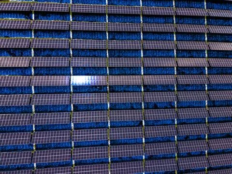 Solar panels across a large area capture sunlight during the day and help g.. Stock Photos