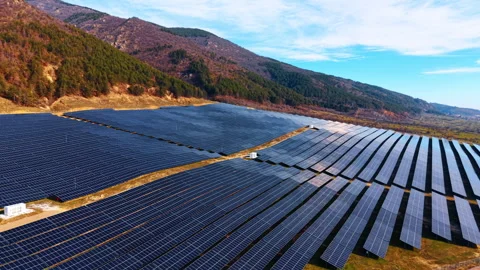 Solar panels across a mountain valley hillside, aerial view shows dark modules, Stock Footage 337912616