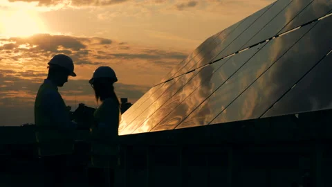 Solar panels and two workers silhouettes talking. Stock Footage 98133418