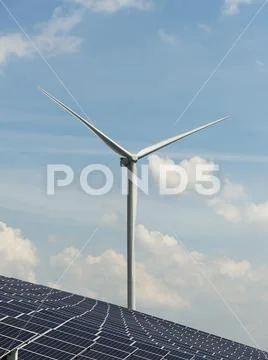 Solar panels and wind turbines, solar field, on a former waste dump. Stock Photos