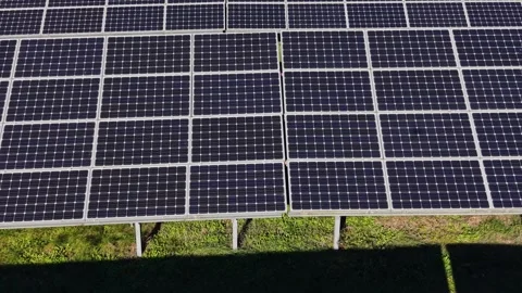 Solar panels are arranged in rows on green grass during daylight hours Stock-Footage 334028510