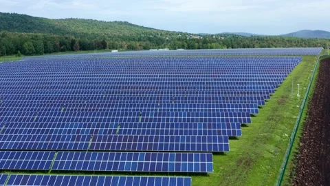 The solar panels are blue close-up. The rural road runs next to the solar farm Stock Footage 155849563